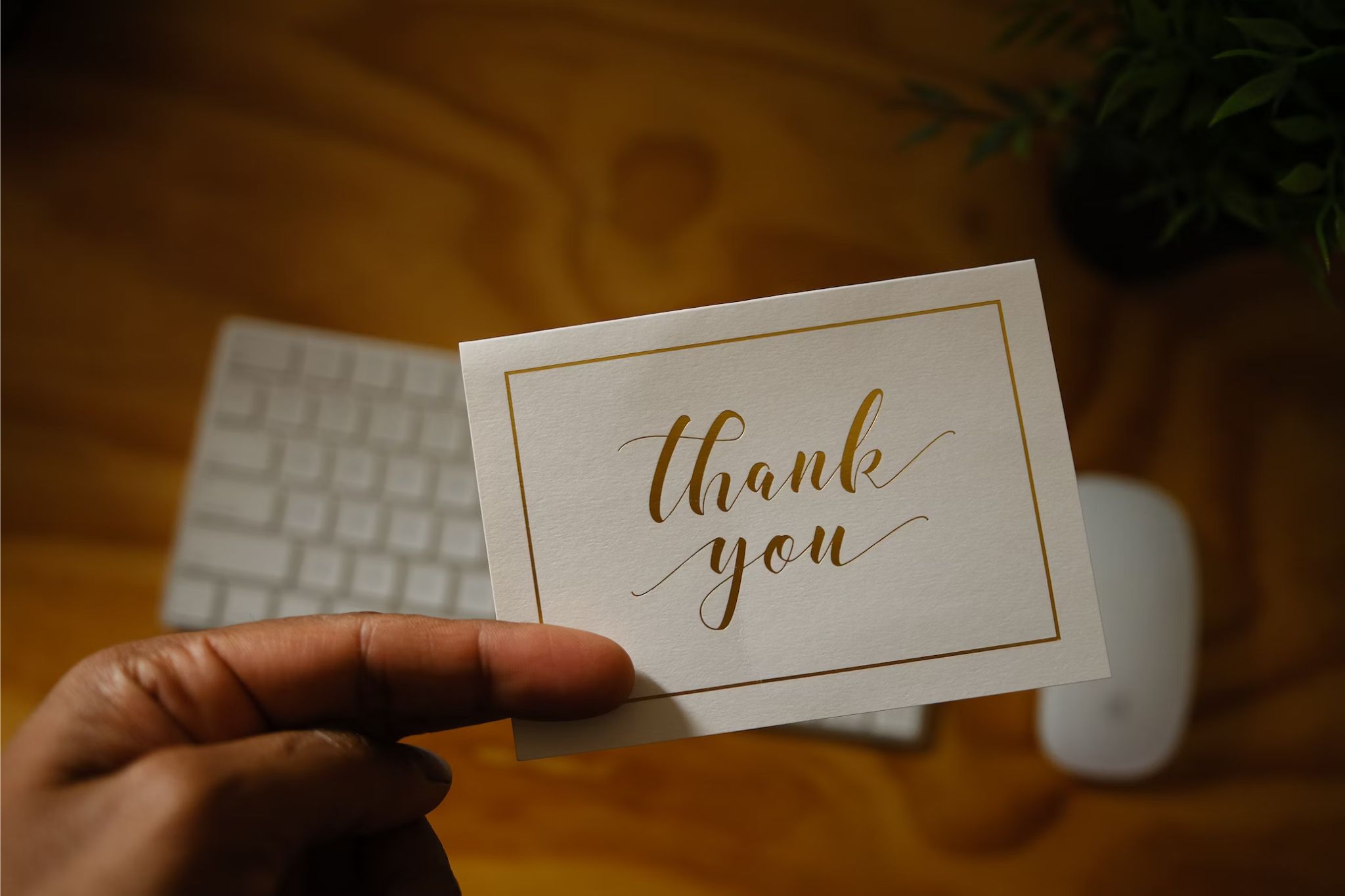 A hand holding a thank you card